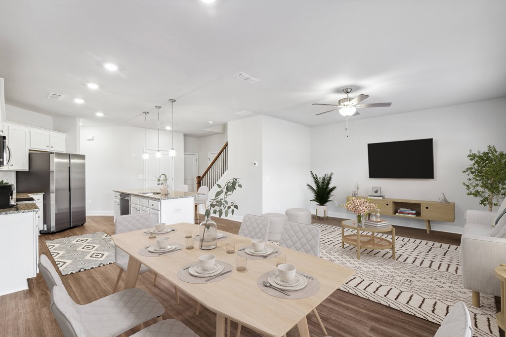 a living room and dining room with a table and chairs