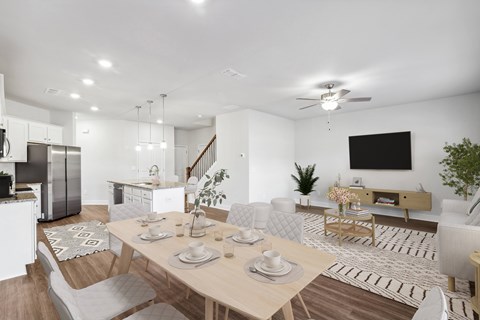 a living room and dining room with a table and chairs