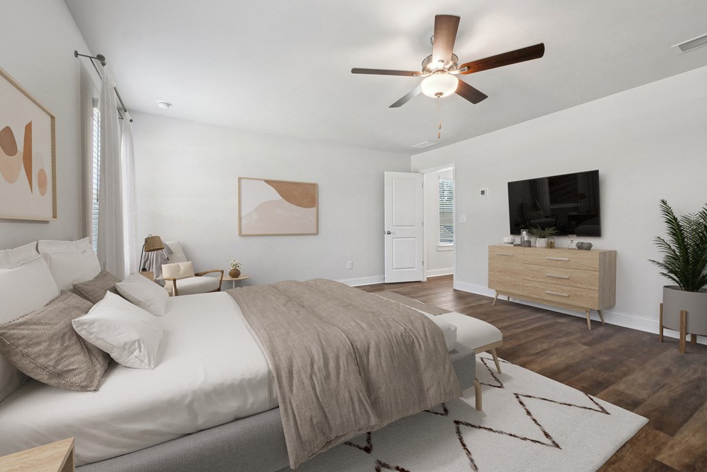 Another view of the spacious primary suite showcasing a grand bed and modern ceiling fan.