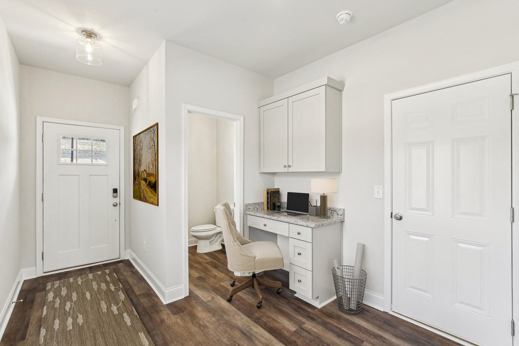 a room with a desk and a chair and a toilet