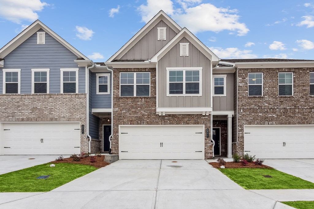 a house with two garage doors and a sidewalk in front of it