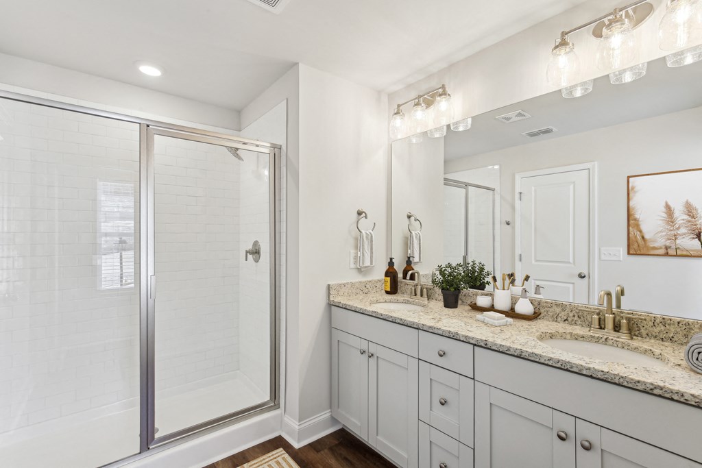 a bathroom with a shower and a sink and a mirror