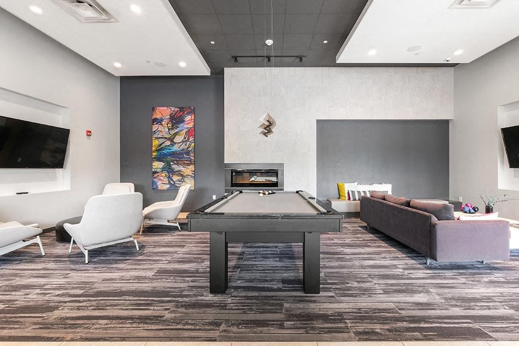 a gathering room with a pool table and a tv