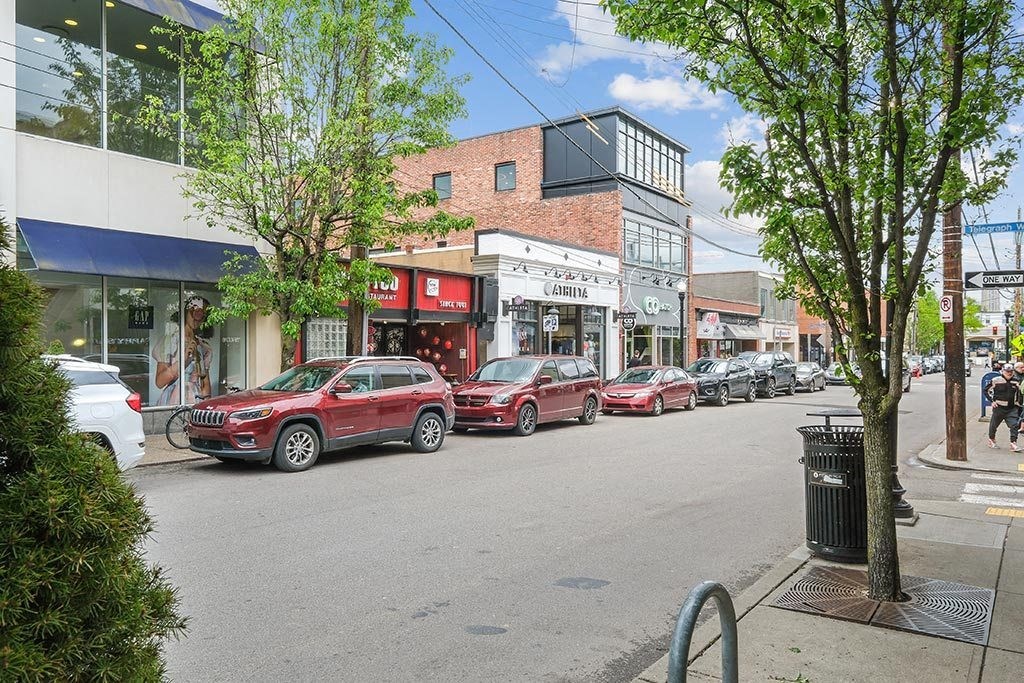 a row of red cars parked on the side of a street
