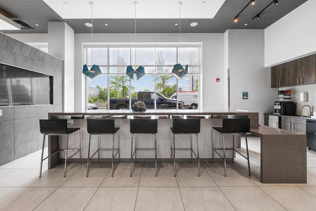 a kitchen with bar stools and a large window