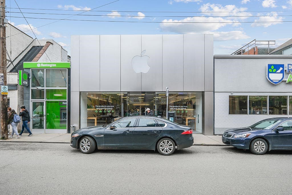 the front of a store with two cars parked in front of it