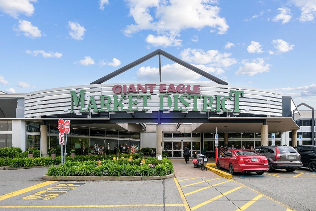 the front of a mall with cars parked in front of it