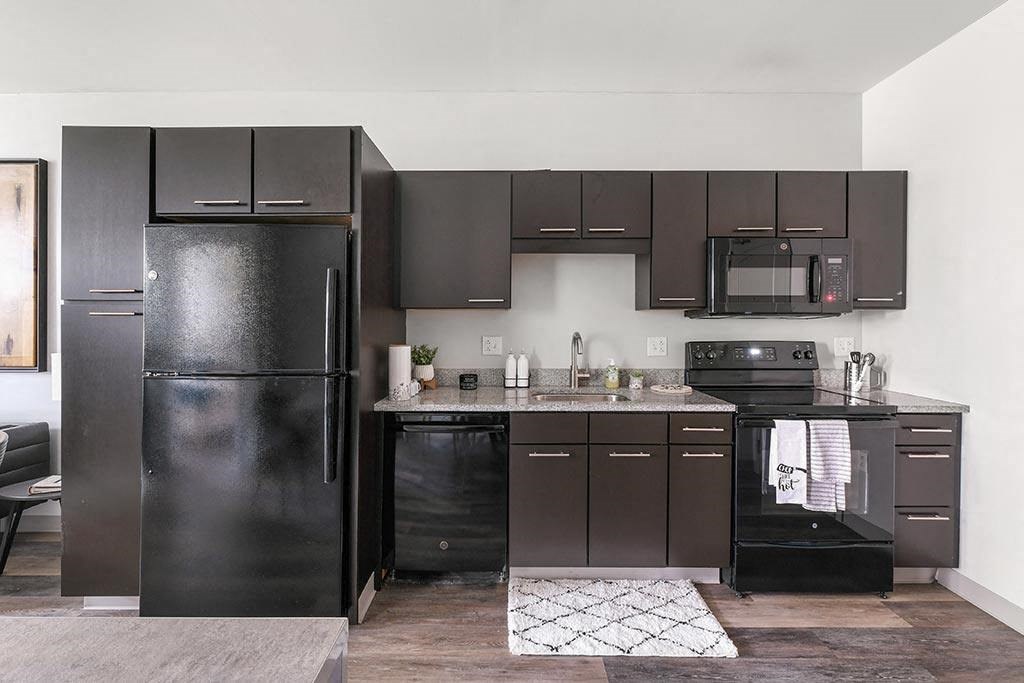 a kitchen with black appliances and black cabinets