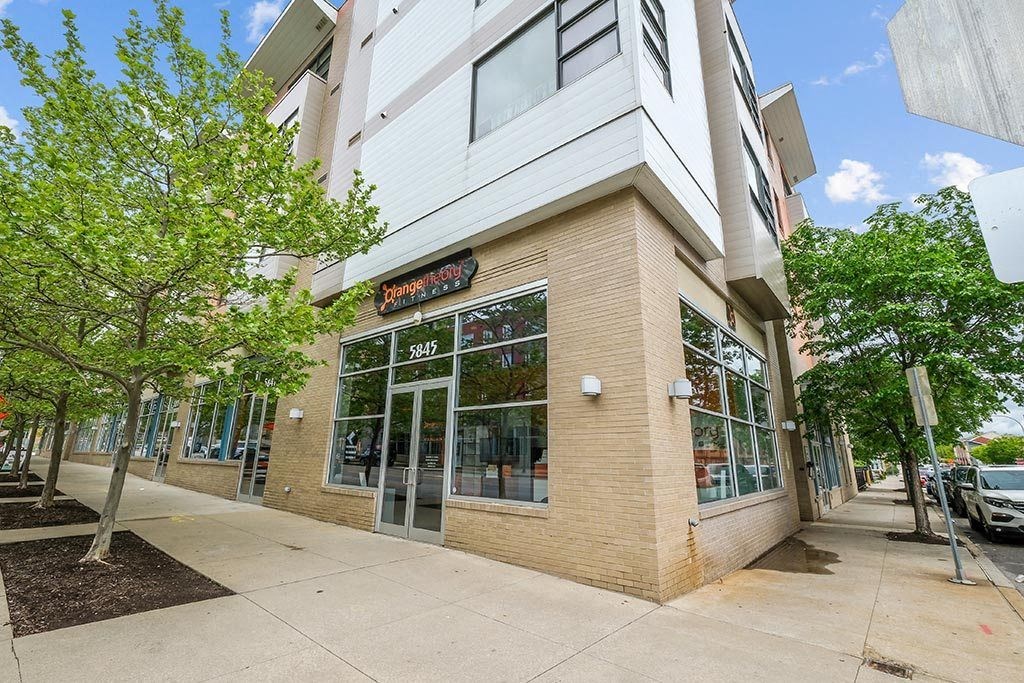 the outside of a building with a sidewalk and trees