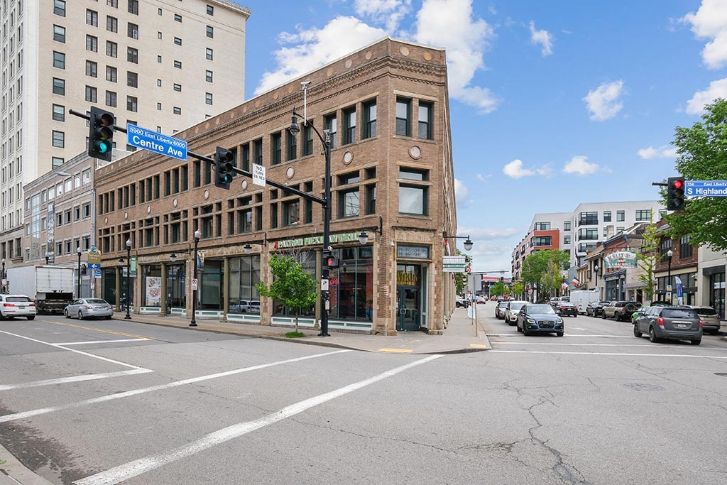 an empty city street with a building on the corner