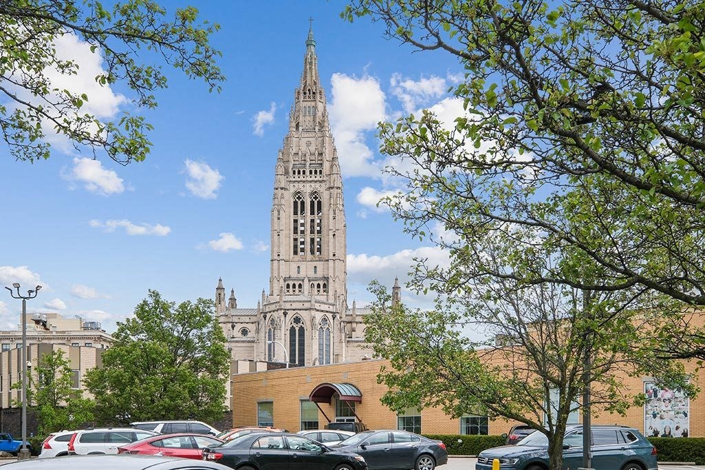 a tall building with a tall tower and a building with cars