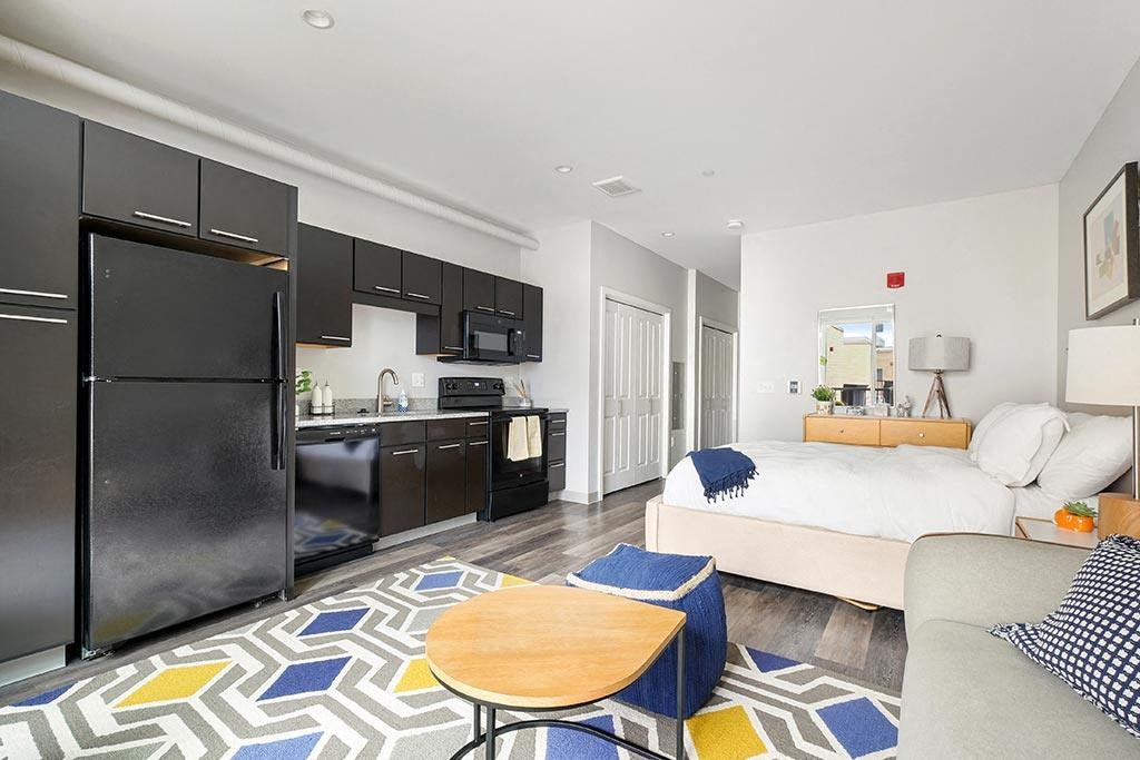 a studio apartment with a kitchen and a bed