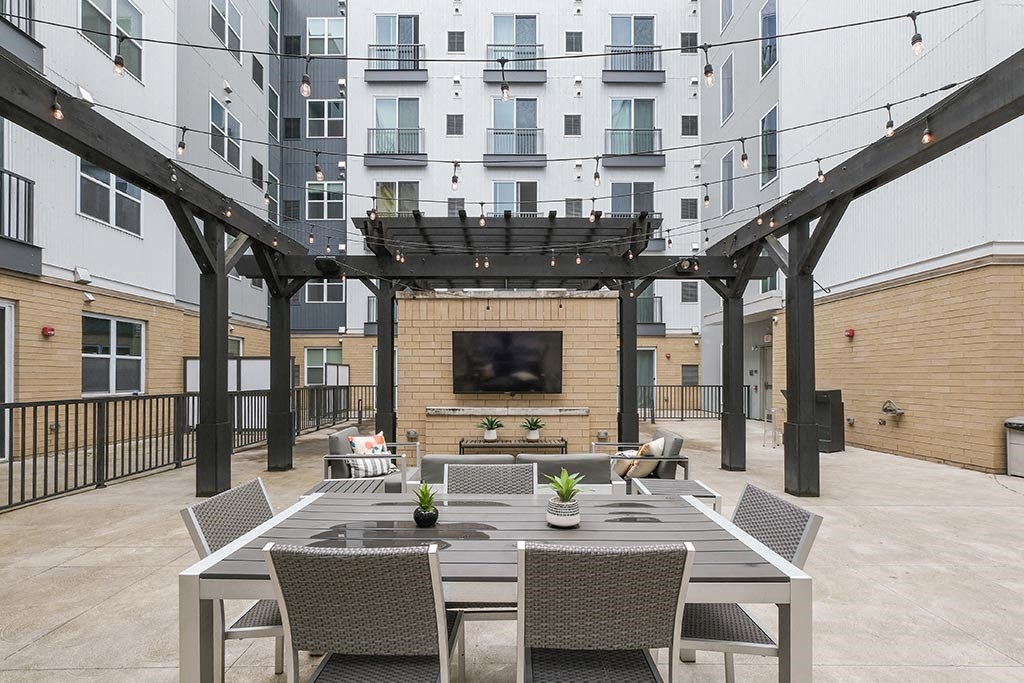 a patio with a table and chairs and a fireplace