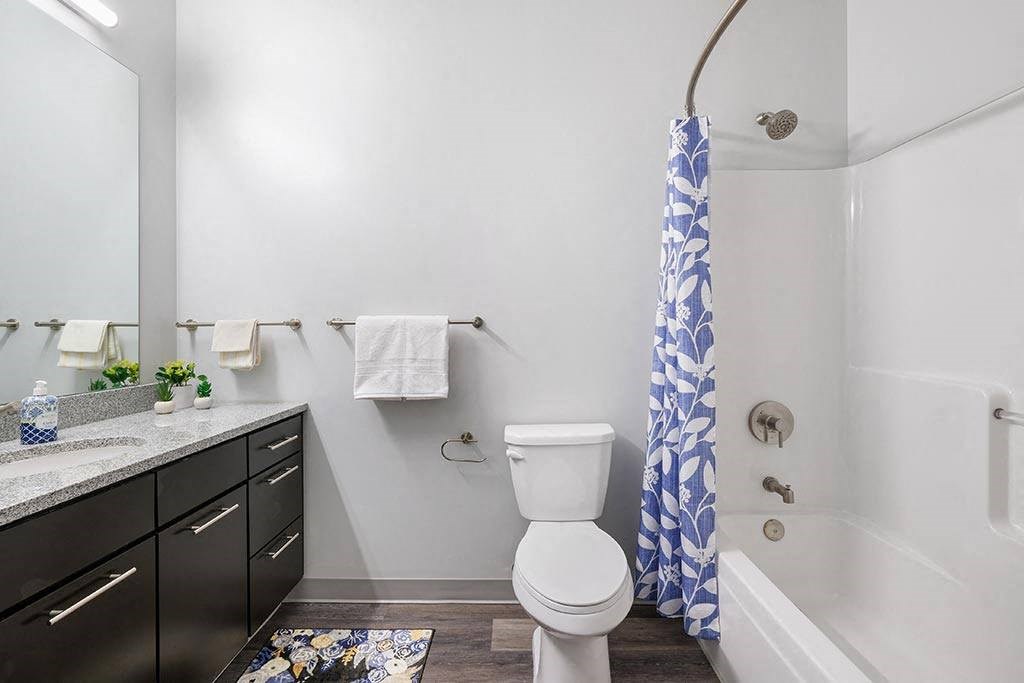 a bathroom with a toilet and a tub and a sink