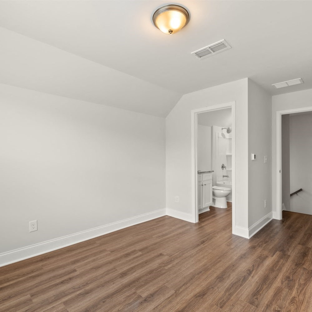 a living room with a hard wood floor and white walls