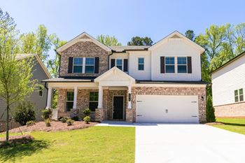 a house with a white garage door in front of a lawn