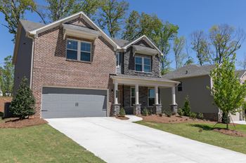 a large brick house with a white sidewalk in front of it