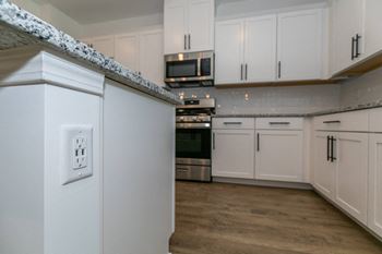 a kitchen with white cabinets and stainless steel appliances