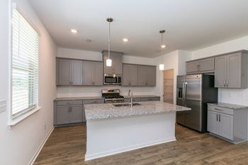 a kitchen with a large island and a stainless steel refrigerator