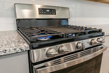 a kitchen with two stainless steel ovens and a granite counter top