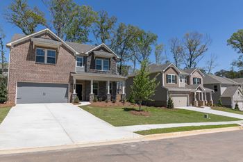 a house with a driveway and a lawn in front of it