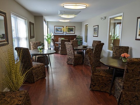 A living room with brown patterned chairs and a wooden floor.