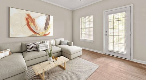 A living room with a grey couch, a wooden coffee table, and a painting on the wall.