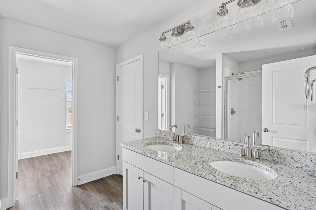 Primary bathroom with double vanity, and walk-in shower.