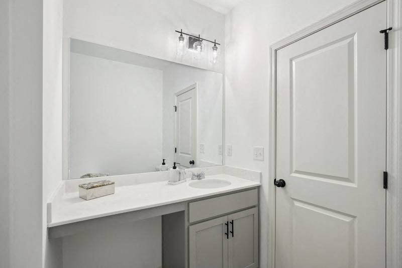 a white bathroom with a sink and a mirror