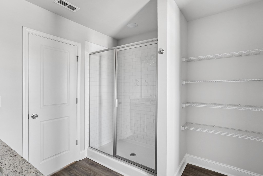 Alternate view of walk-in shower and linen storage.