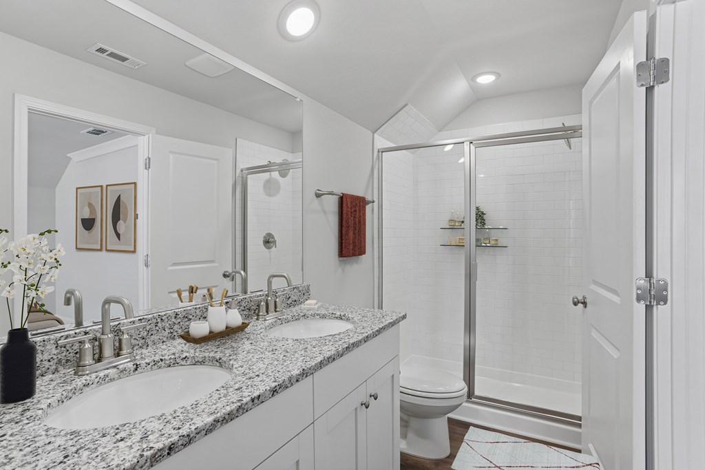 Primary bathroom with double vanity, walk-in shower.