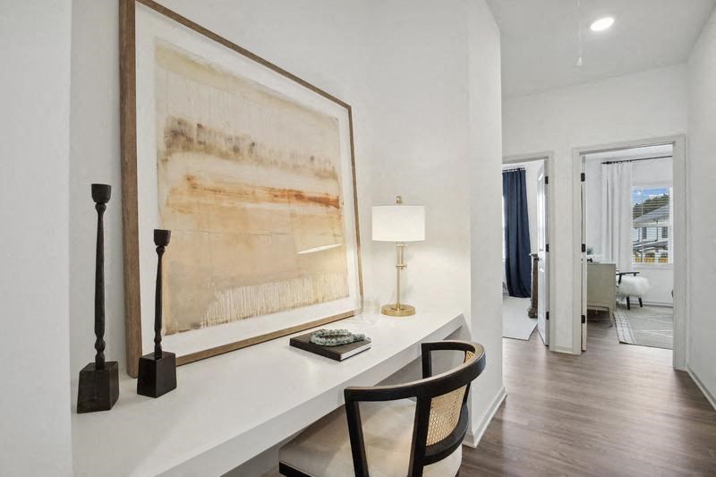 a desk with a large picture and a chair in a room