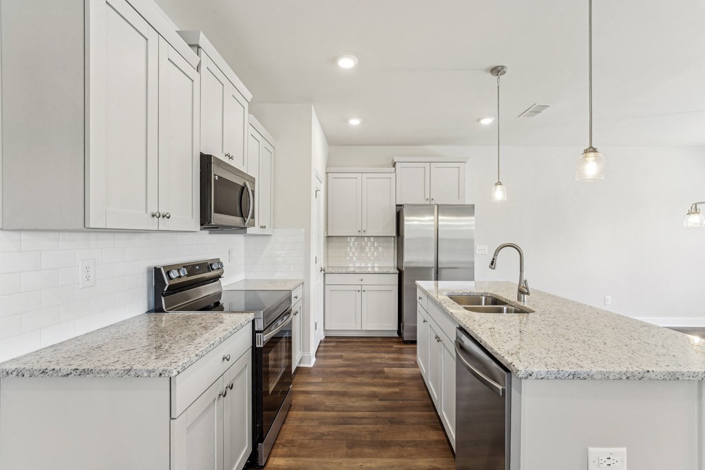 a white kitchen with marble counter tops and white cabinets