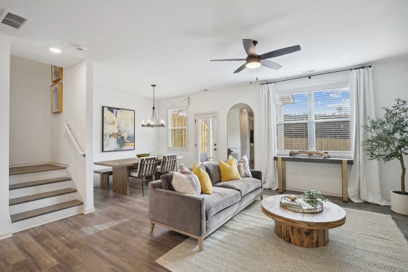 a living room with a couch and a coffee table and a ceiling fan