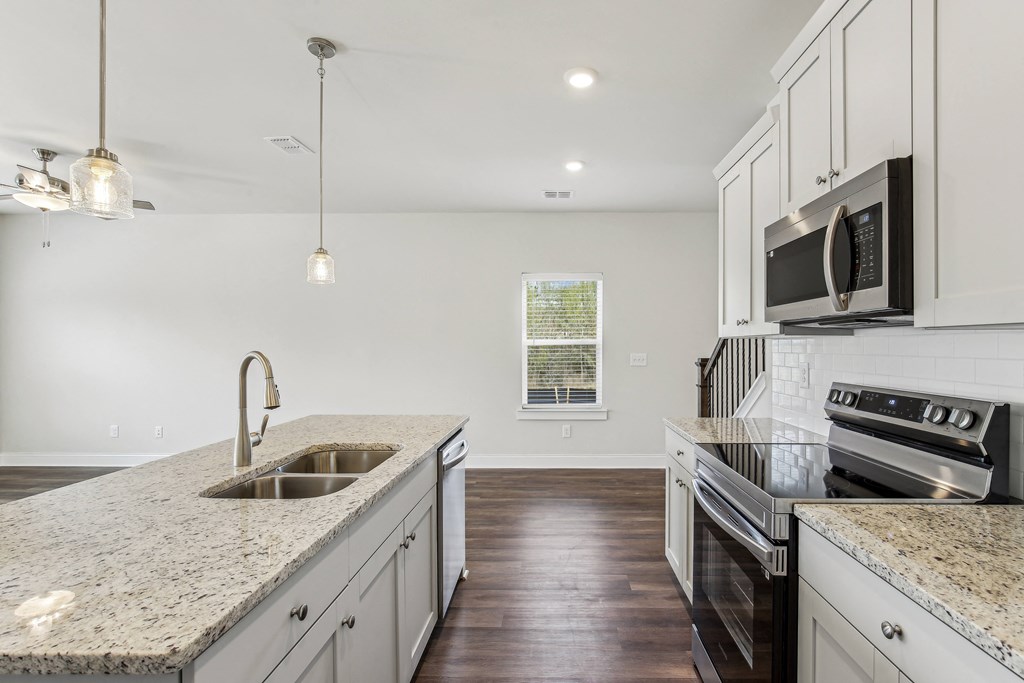 a kitchen with granite counter tops and white cabinets