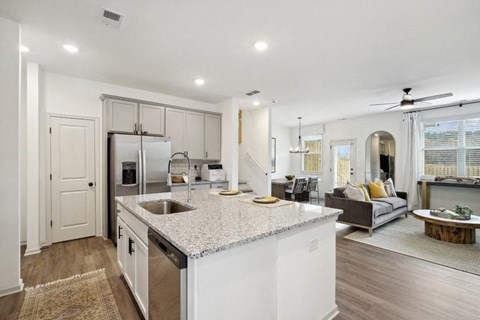 Elegant, open-concept kitchen with stainless steel appliances, generous storage, and a seamless flow into the living area.