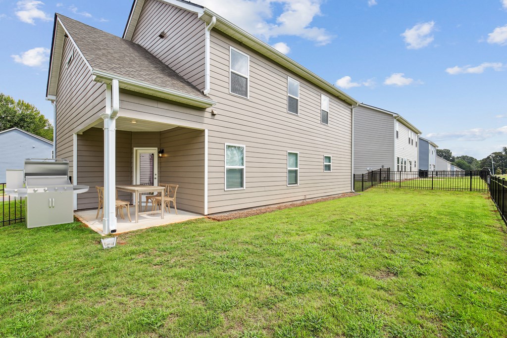 Covered back patio with fenced in yard.