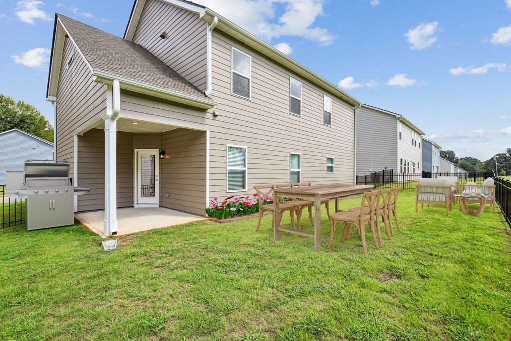 Covered back patio with fenced in yard.