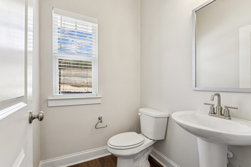a bathroom with a toilet and a sink and a window