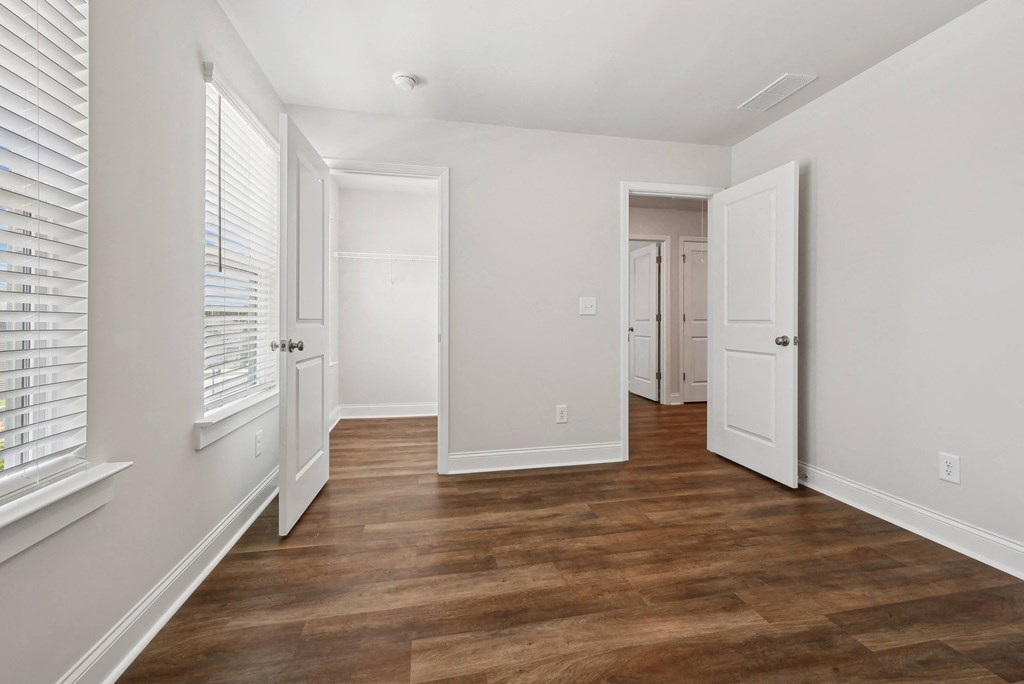 a living room with a hard wood floor and white walls