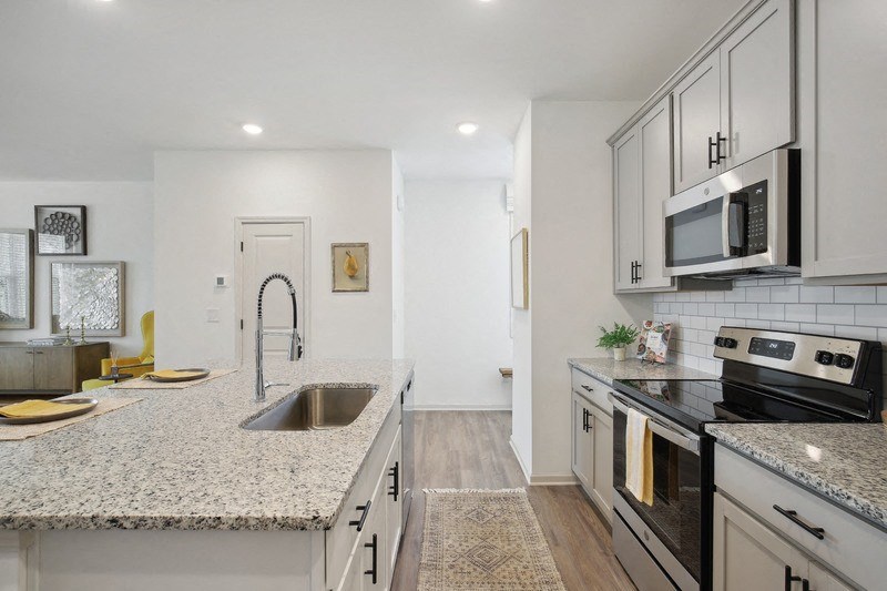 a renovated kitchen with granite counter tops and white cabinets
