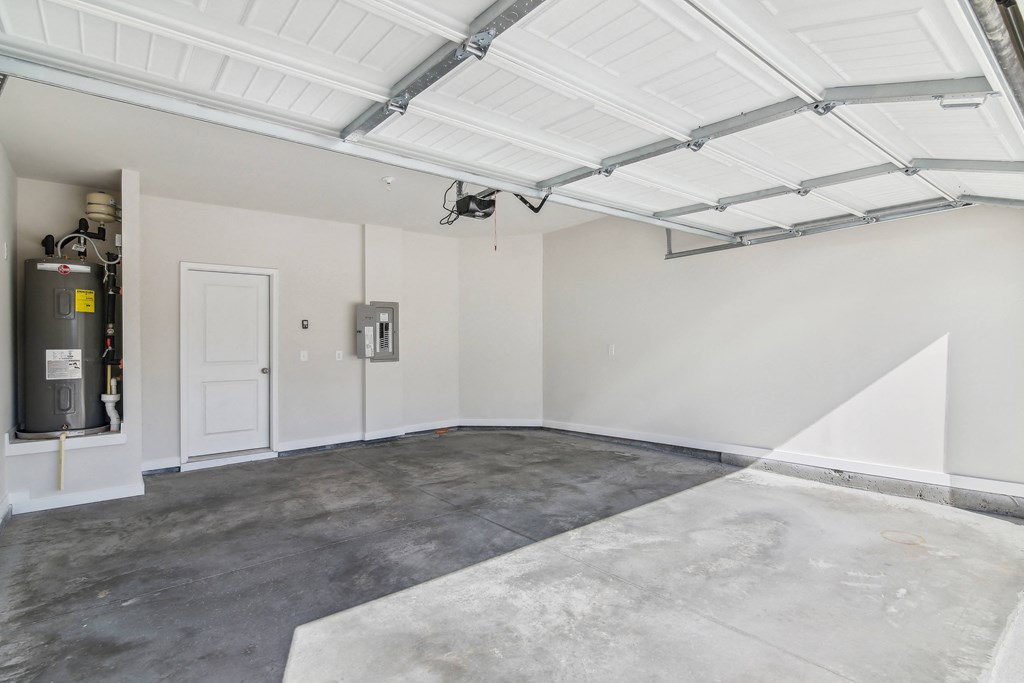 the interior of a garage with white walls and a concrete floor