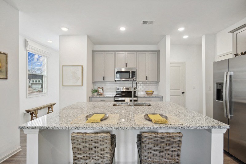 a kitchen with a marble counter top and stainless steel appliances