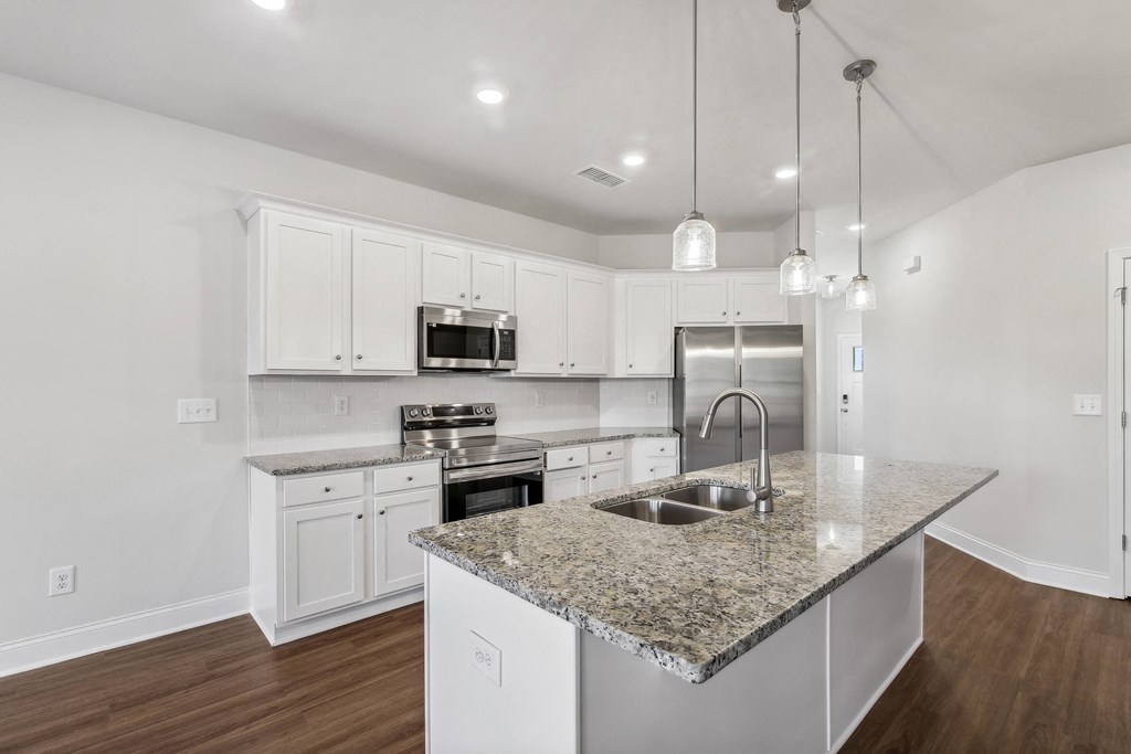a kitchen with white cabinets and a granite counter top