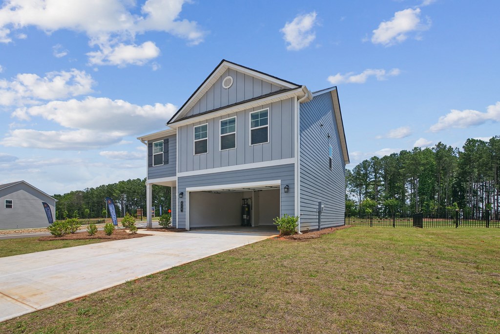 a blue house with a driveway and a garage door