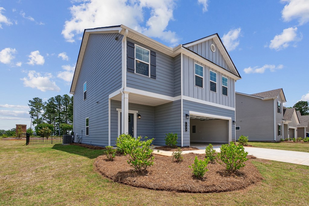 a blue house with a front yard and a driveway