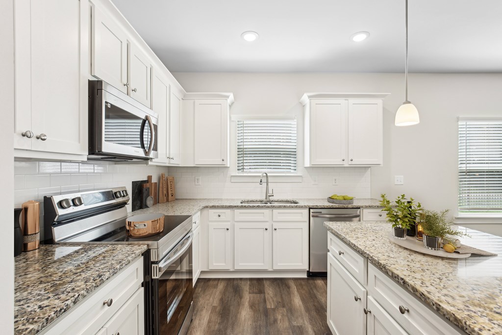 Spacious kitchen with an island, ample storage, stainless steel appliances and view into the living room.