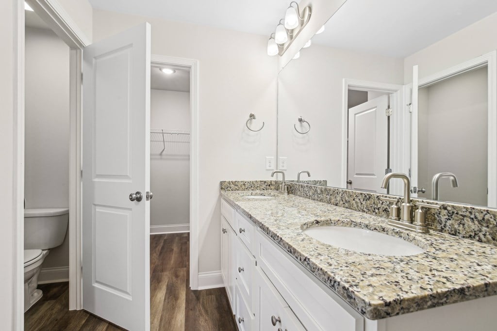 Primary bathroom with double vanity, walk-in shower and walk-in closet.