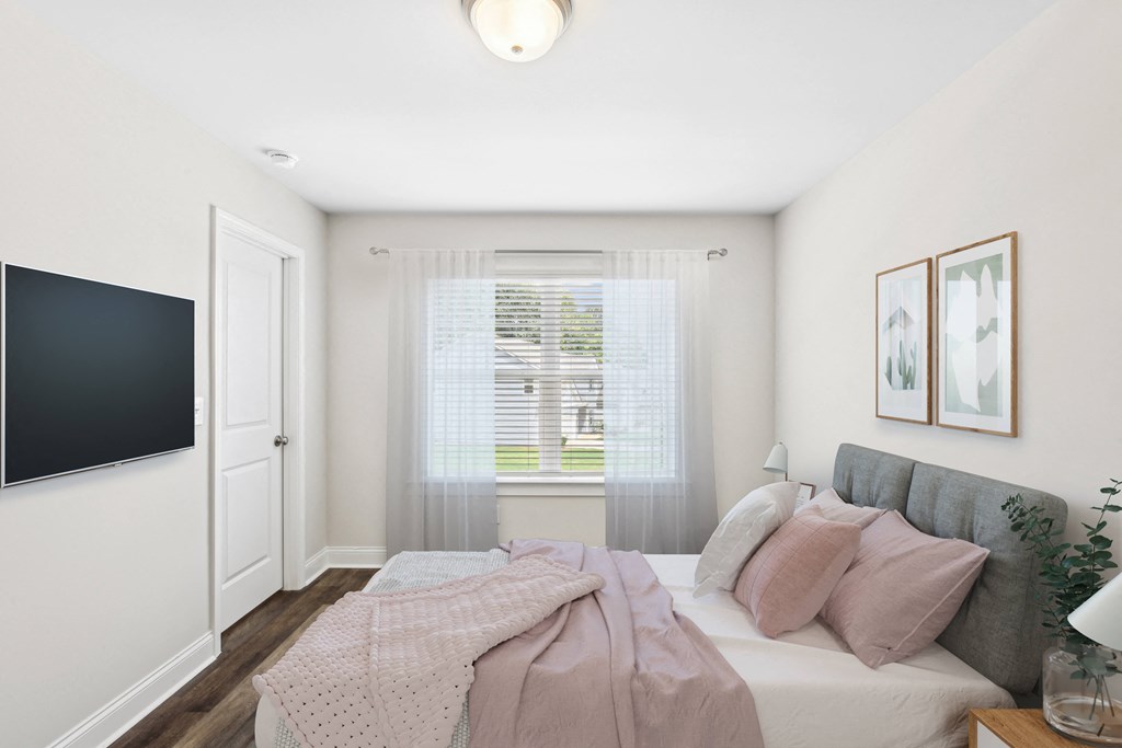 Secondary bedroom with queen bed, large sunlit window.