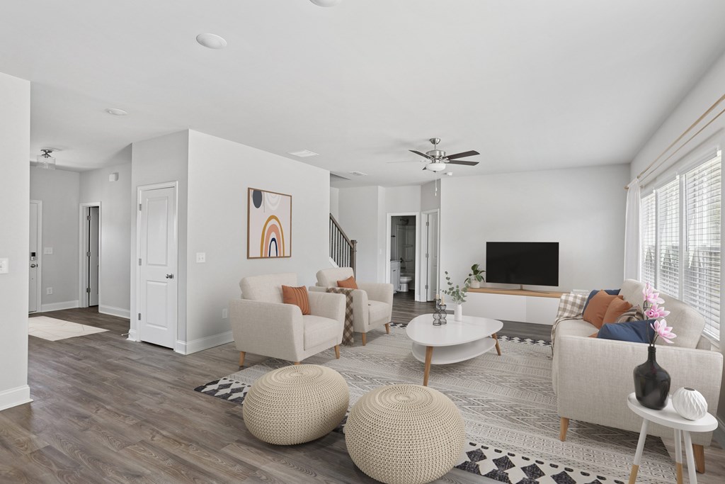 Spacious living room with a plush couch, accent chair, and sleek entertainment center
